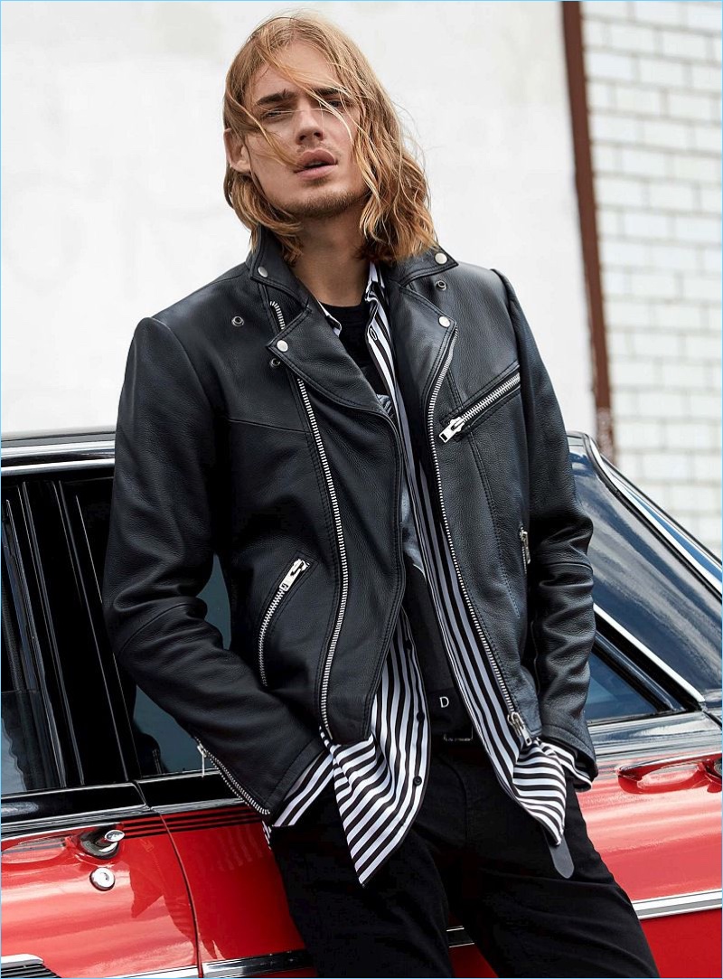 Dutch model Ton Heukels wears a leather jacket with a striped shirt and jeans.