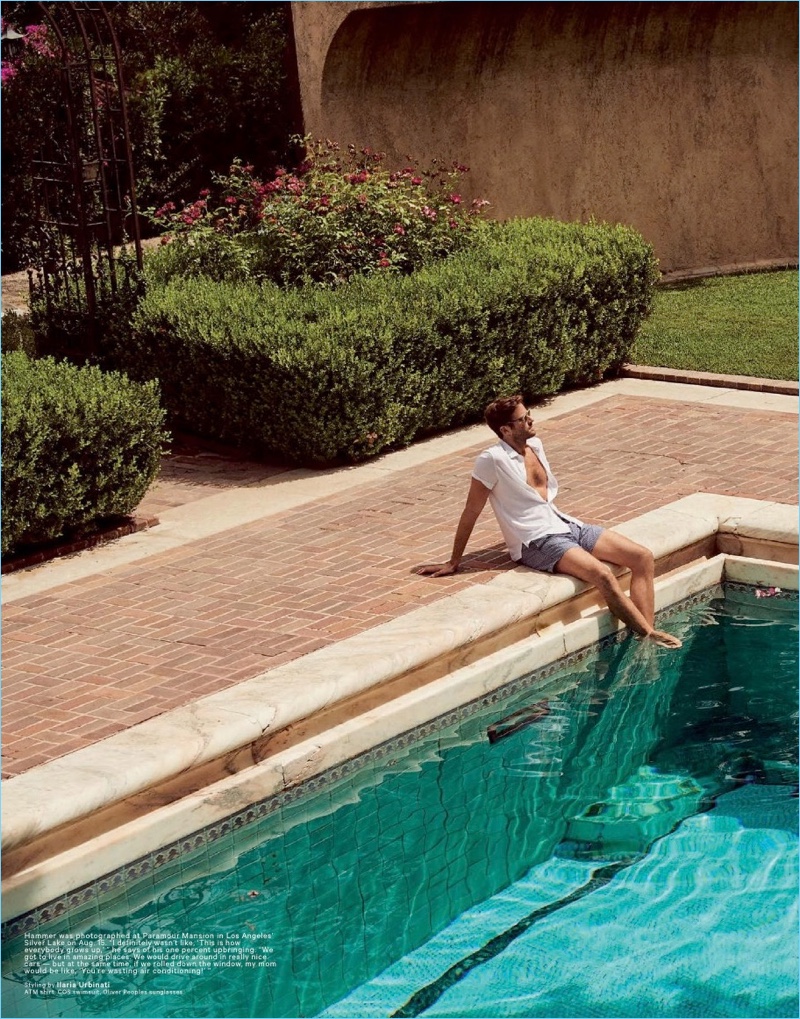 Relaxing poolside, Armie Hammer wears COS swim shorts with an ATM shirt and Oliver Peoples sunglasses.