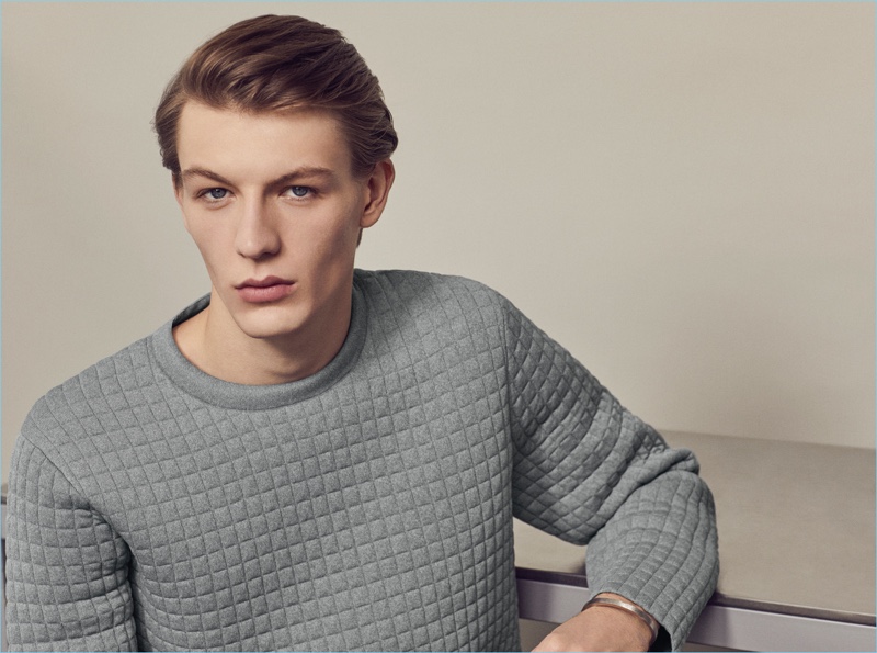 English model Finnlay Davis dons a textured COS pullover in grey.