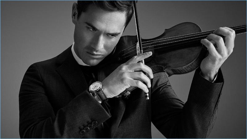 Playing the violin, Charlie Siem wears a Prada wool suit and sweater. He also sports a Jil Sander shirt and Jaeger-LeCoultre watch.