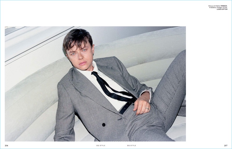 Relaxing, Dane DeHaan wears a Versace suit.