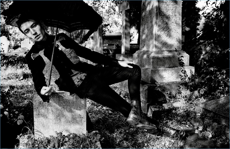 Taking to a cemetery, Ezra Miller wears a jacket and earrings by Alexander McQueen. The actor also wears an Ann Demeulemeester shirt, Dolce & Gabbana pants, and Frye boots.