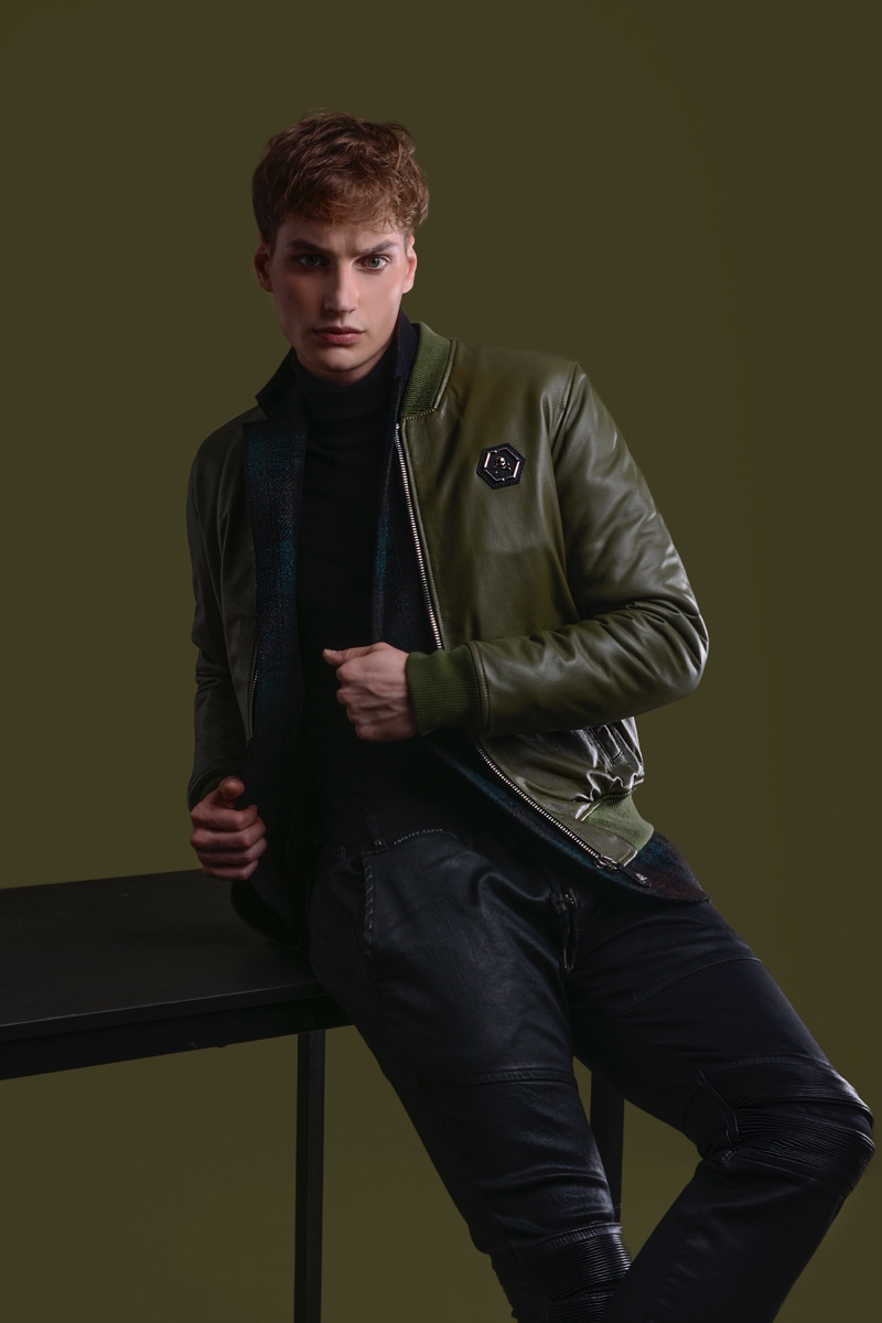 Felix Velbinger wears check jacket Daks, pants and green leather jacket Philipp Plein.