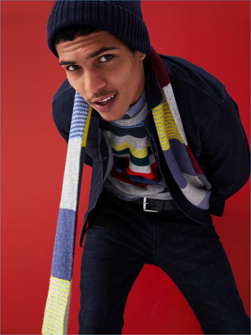 Gap proposes colorful stripes. Here, Geron McKinley models a stripe sweater with a chambray shirt. He also wears a striped scarf, denim jacket, and skinny-fit jeans.