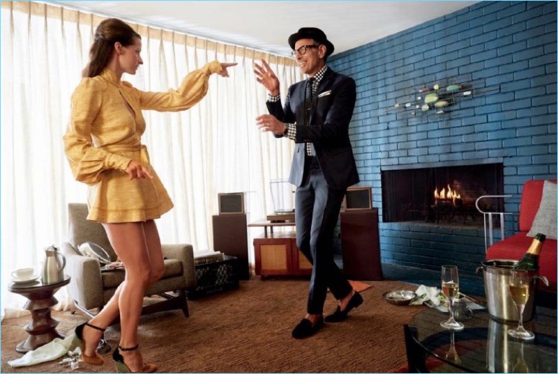 Dancing with his wife, Jeff Goldblum wears an Emporio Armani suit. The actor also rocks Stubbs & Wootton loafers, a Borsalino hat. His suit is complete with a shirt, pocket square, and tie by Eton.