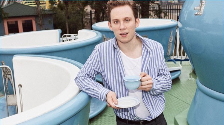 Enjoying a cup of tea, Joe Cole wears an Acne Studios striped oxford shirt and Sunspel tank. He also sports Maison Margiela checked trousers and a Lanvin leather belt.