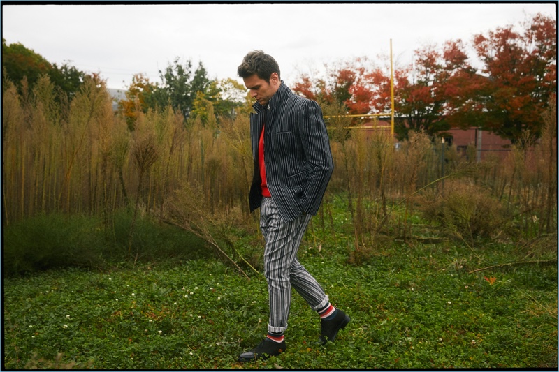 Mixing patterns, Jonathan Groff wears a Vivienne Westwood top, jacket, and pants with a H&M sweater. He also sports Thom Browne shoes and H&M socks.