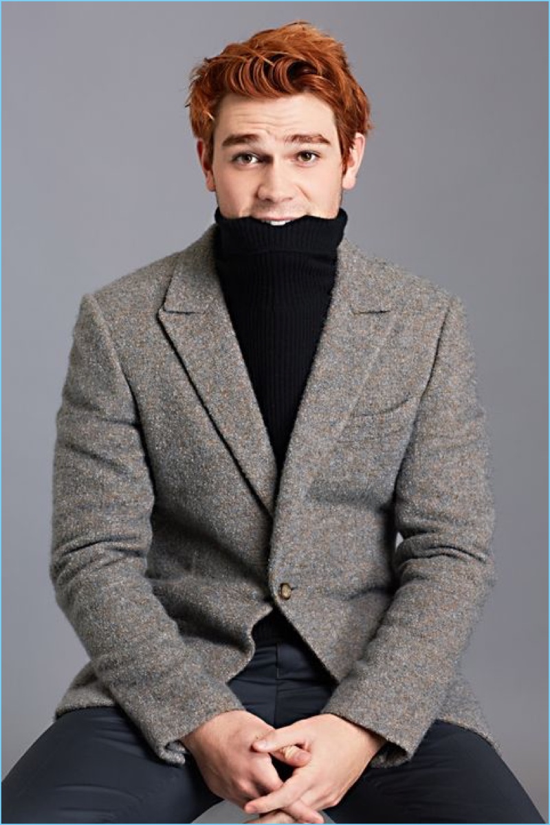 Pouring on the charm, KJ Apa wears a Theory turtleneck sweater with an Ermenegildo Zegna Couture suit jacket and Tommy Hilfiger trousers.