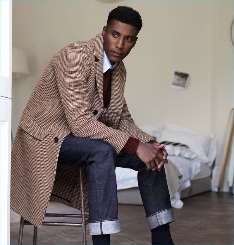 Wearing standout pieces by Mr P., Joshua Payne sports a houndstooth overcoat and Shetland wool sweater. He also models a white shirt and slim-fit selvedge denim jeans.
