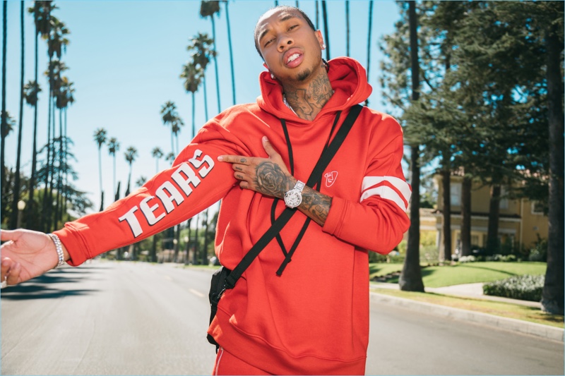 Tyga rocks a red sweatshirt and joggers from his boohooMAN collaboration.