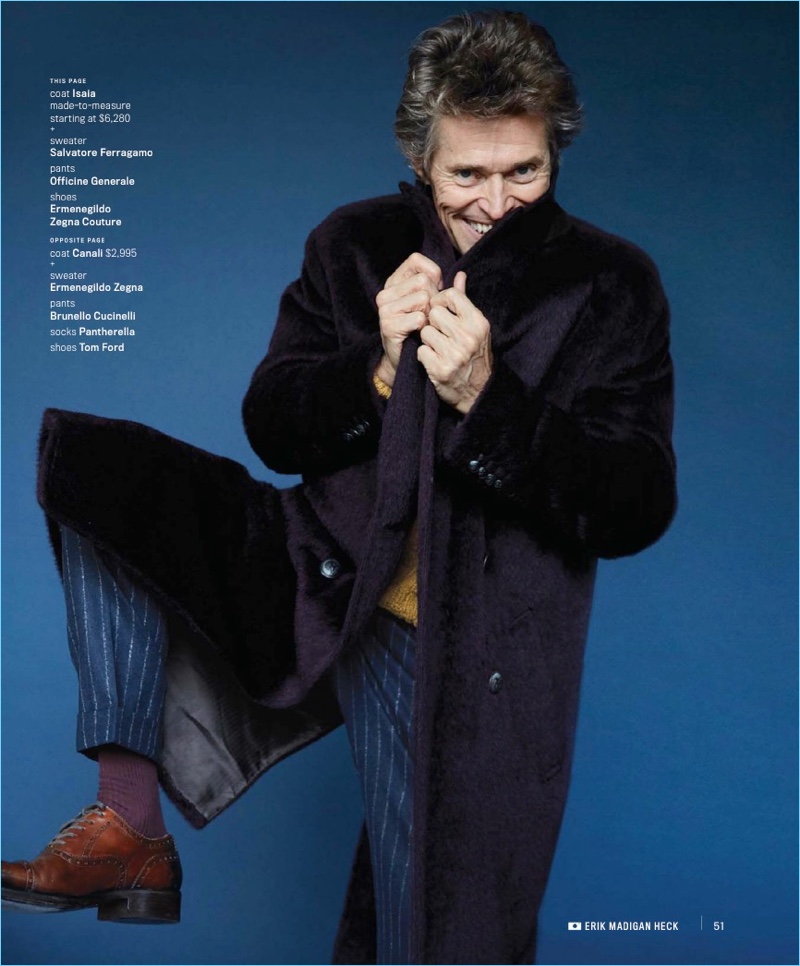 All smiles, Willem Dafoe wears a ISAIA coat with a Salvatore Ferragamo sweater. Dafoe also sports Officine Generale pants and Ermenegildo Zegna Couture shoes.