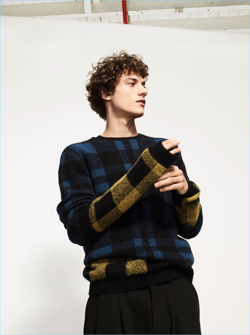 Model Serge Rigvava dons a check sweater with Zara Man trousers.
