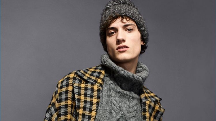 Serge Rigvava wears a Zara Man oversized cable-knit turtleneck with a check winter coat.