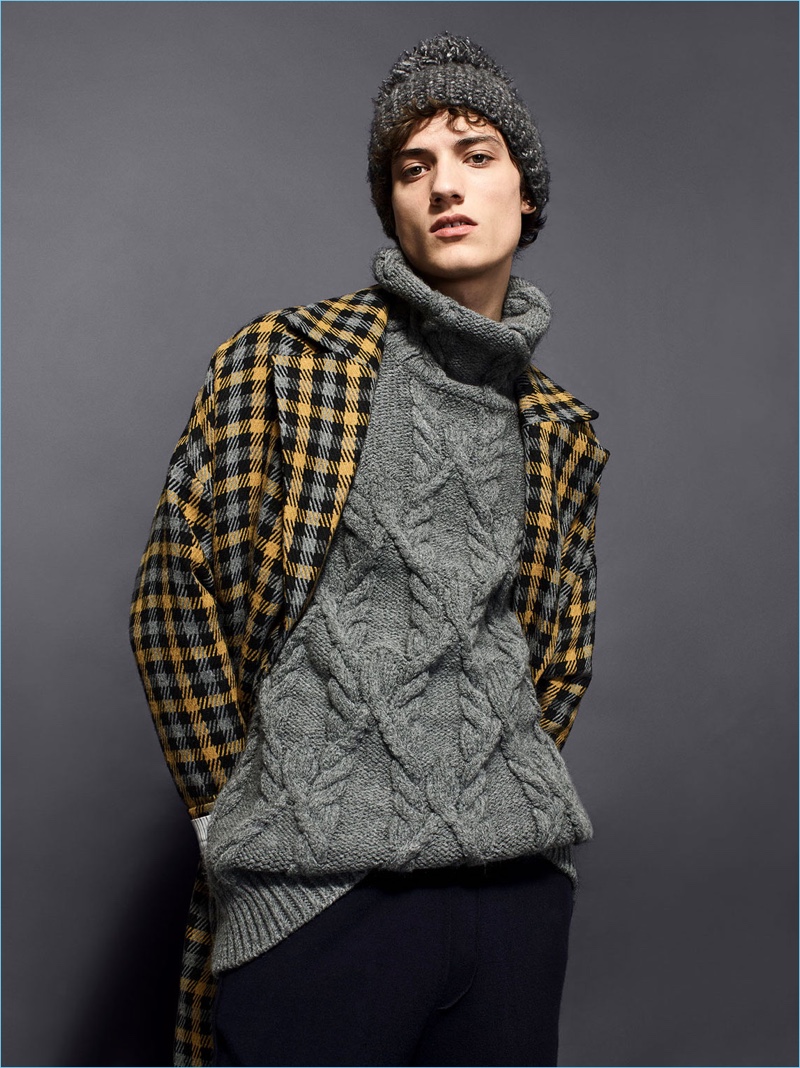 Serge Rigvava wears a Zara Man oversized cable-knit turtleneck with a check winter coat.