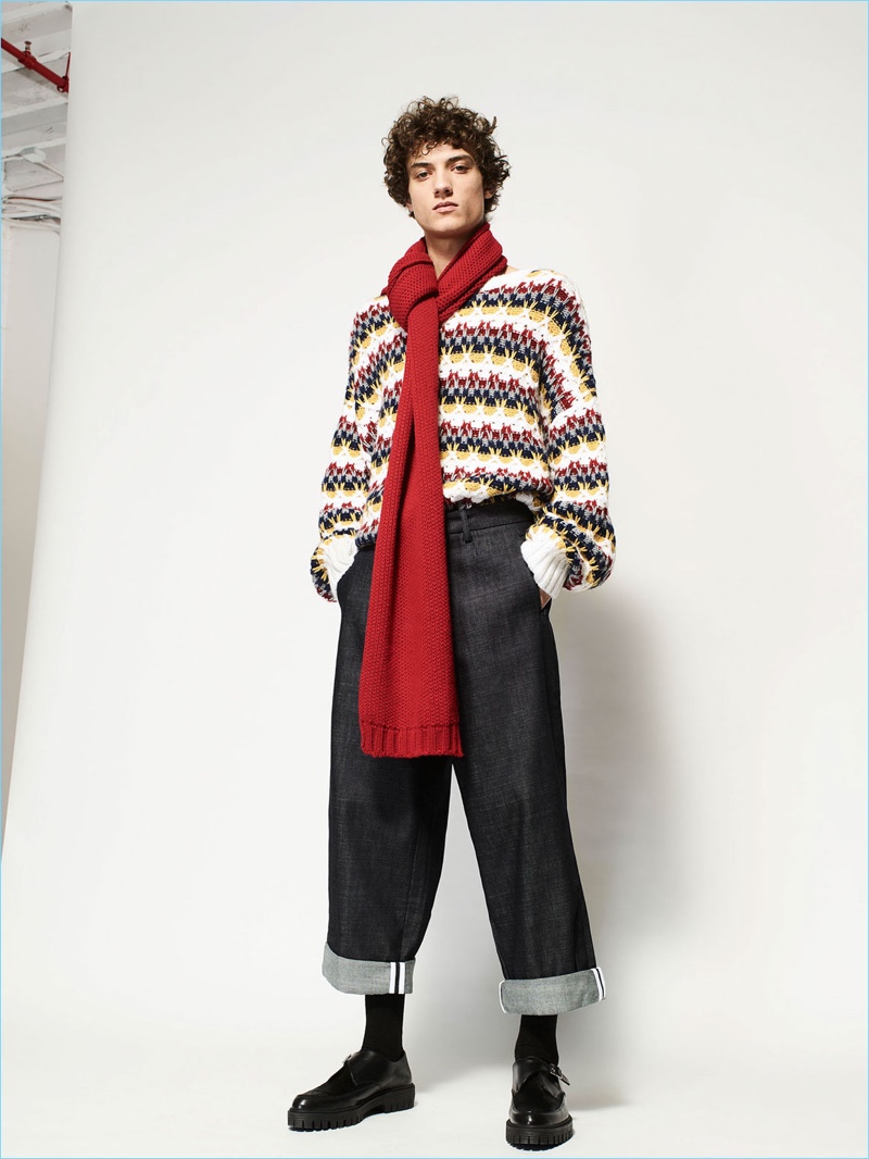 Making a seasonal play, Serge Rigvava models a Zara Man jacquard knit with a red scarf and smart trousers.