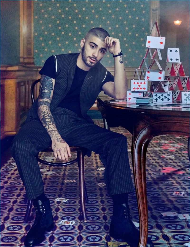 Connecting with Billboard, Zayn Malik wears a Tom Ford t-shirt with a pinstripe vest and trousers by Dior Homme. Malik also dons Christian Louboutin boots.