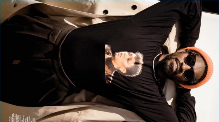 Appearing in a shoot for GQ Style, André 3000 Benjmain wears a BOSS coat and pants with a custom t-shirt.