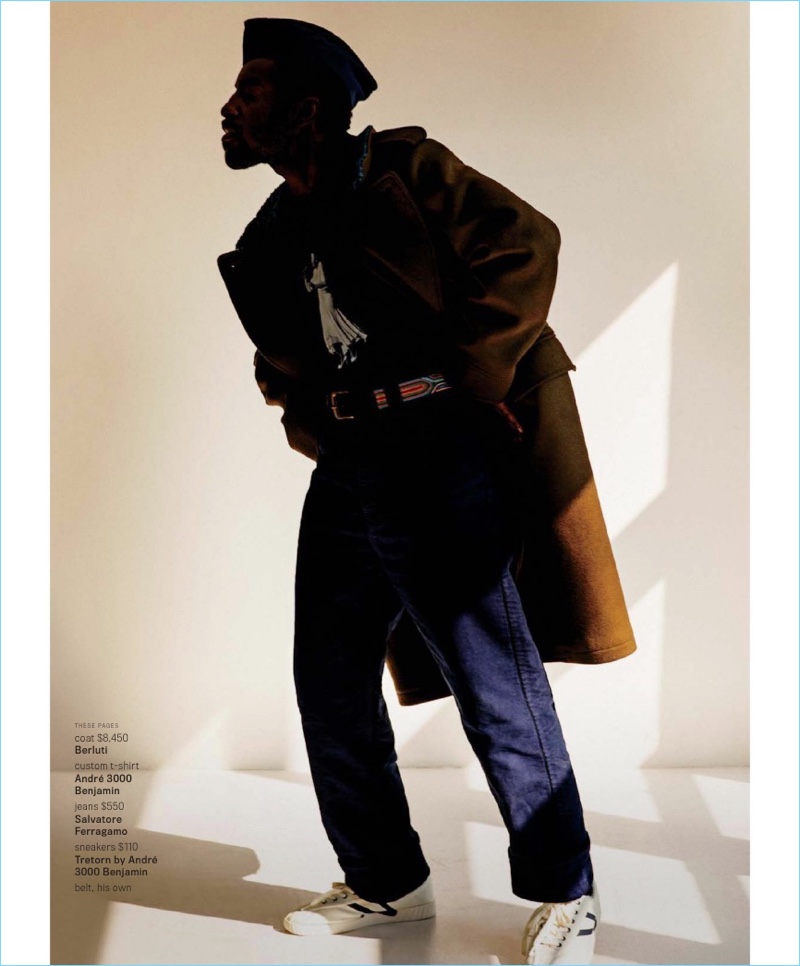 Casting a stylish silhouette, André 3000 Benjmain dons a Berluti coat and custom t-shirt. He also wears Salvatore Ferragamo jeans and Tretorn by André 3000 Benjamin sneakers.