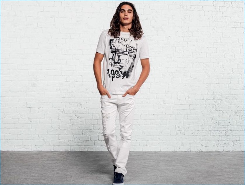 Model Vito Basso sports a white denim look by Armani Exchange.