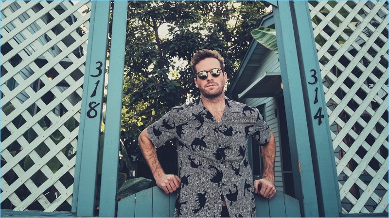 Actor Armie Hammer dons a Saint Laurent camp-collar shirt with AMI trousers, and Oliver Peoples sunglasses.