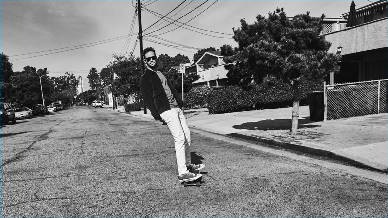 Skateboarding, Armie Hammer wears a Kent & Curwen corduroy bomber jacket. Hammer wears a Maison Margiela t-shirt, Acne Studios jeans, and Converse sneakers as well.