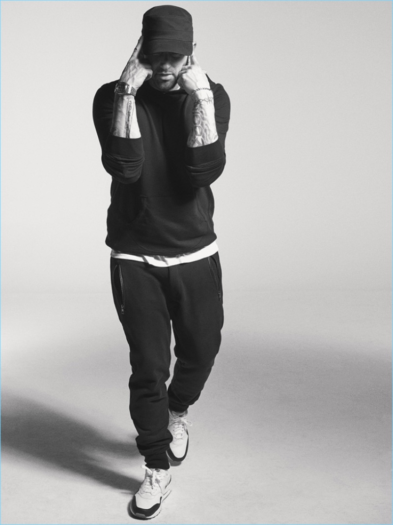 Connecting with Interview magazine, Eminem wears a Reigning Champ hoodie with an Armani Exchange t-shirt, Nike sneakers, and Michael Kors pants.