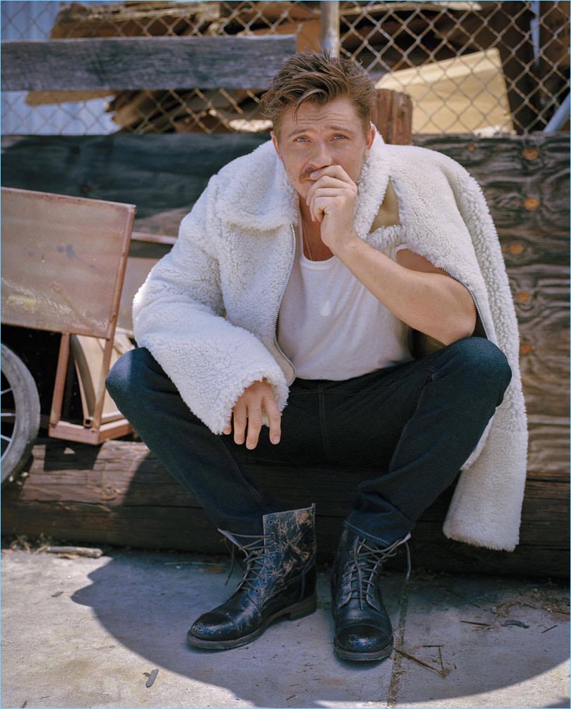 Starring in a photo shoot, Garrett Hedlund wears a Michael Kors jacket and jeans with a Buck Mason t-shirt. He also rocks Bed Stü boots.