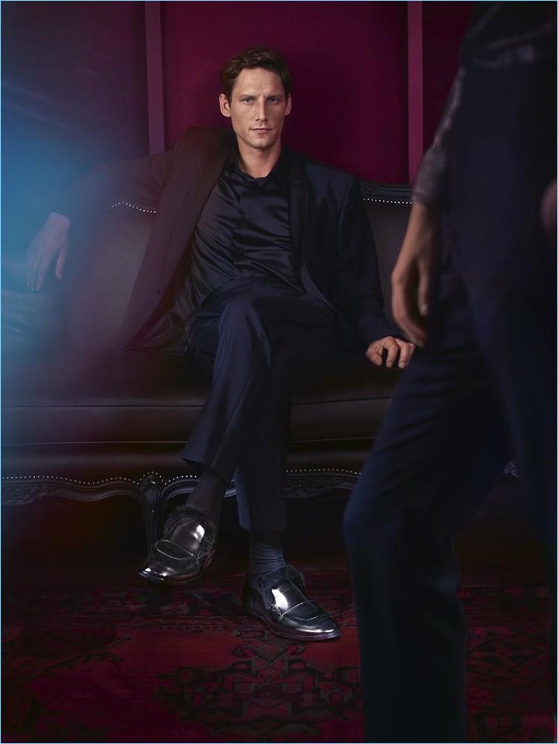 Model Roch Barbot wears Jimmy Choo black brushed off leather loafers with rabbit fur.