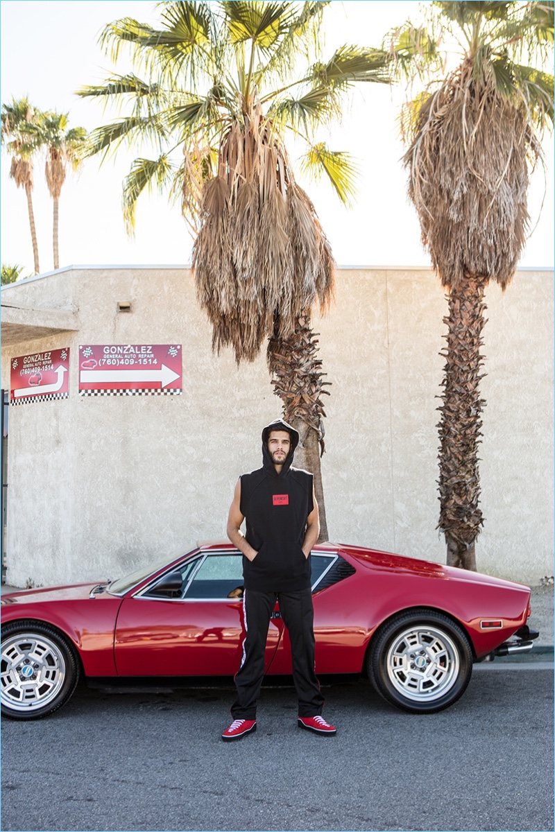 Clad in Givenchy, Landon Falgoust sports a sleeveless hoodie, track pants, and mid-top sneakers.