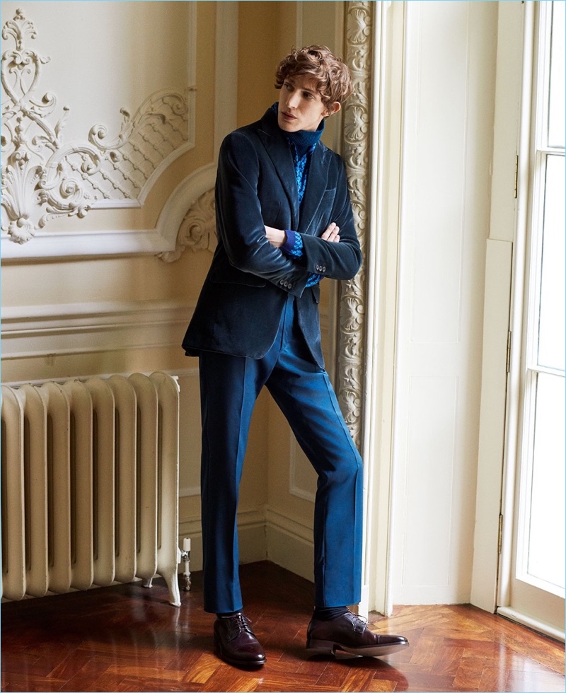 Xavier Buestel wears a Thom Sweeney velvet blazer with a shirt and trousers by Prada. He also layers with a Paul Smith sweater. Xavier's look is complete with Paul Smith's leather derby shoes.