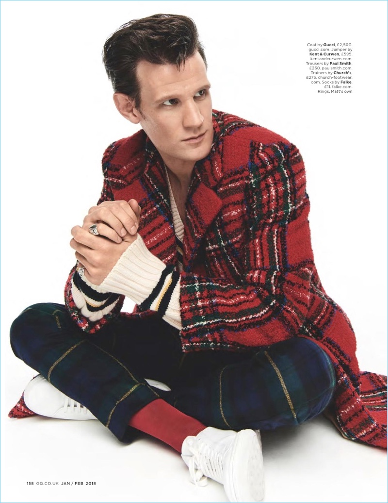 Starring in a British GQ photo shoot, Matt Smith wears a Gucci coat with a Kent & Curwen sweater. Smith also dons Paul Smith trousers and Church's sneakers.