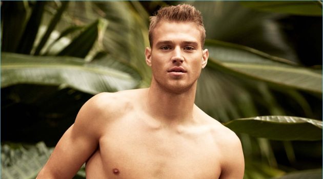 Exotic Escape: Matthew Noszka Rocks Swimwear for Simons American model Matthew Noszka sports I.FIV5 satiny minimalist swim shorts with a playful print.
