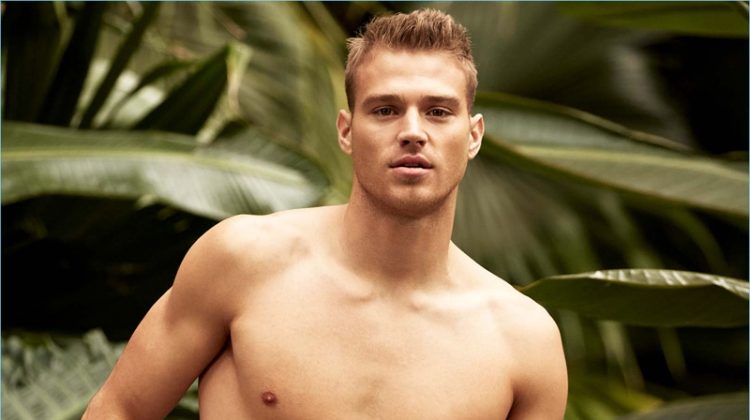 American model Matthew Noszka sports I.FIV5 satiny minimalist swim shorts with a playful print.