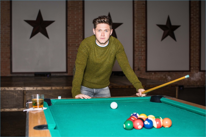 Embracing relaxed style, Niall Horan wears a sweater and t-shirt by Prada with Tom Ford jeans.