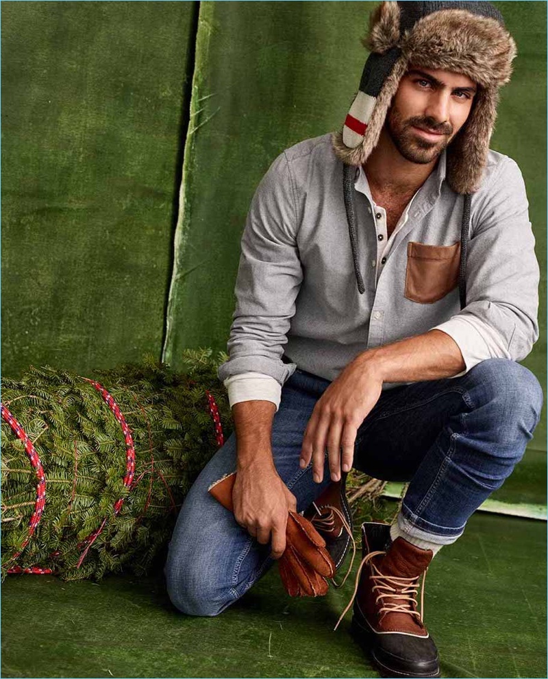 Model Nyle DiMarco wears an oxford shirt, skinny-fit jeans, a wool stock trapper hat, and  Sorel boots.
