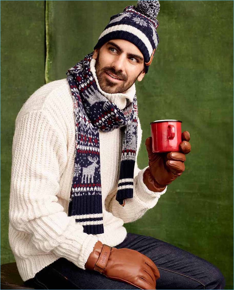 Reuniting with Simons, Nyle DiMarco sports a reindeer print scarf with a sweater and knit beanie by LE 31. He also wears Kodiak sherpa-lined leather gloves.