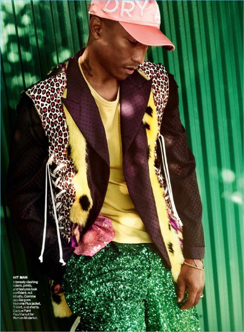 Making a style statement, Pharrell wears a Comme des Garçons Homme Plus jacket, t-shirt, and shorts with a Cactus Plant Flea Market for Human Made cap.