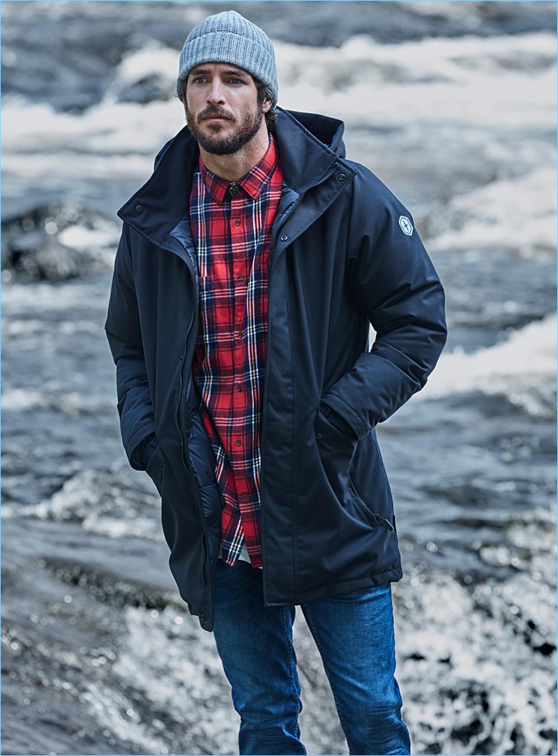 Top model Justice Joslin wears a Quartz Co. parka with a LE 31 grunge tartan shirt, jeans, and a knit beanie.