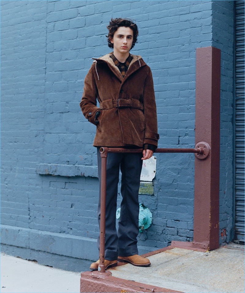 Actor Timothée Chalamet sports a corduroy Prada coat and pants with a Vince shirt and Red Wing Heritage boots.