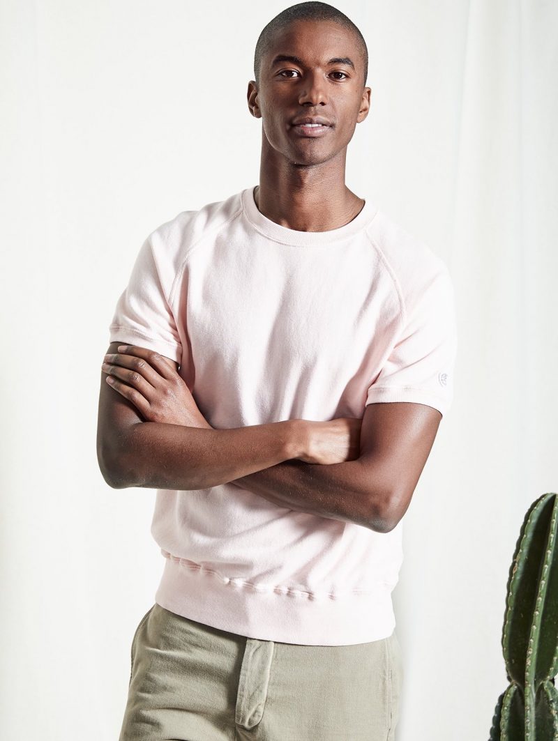 Model Claudio Monteiro wears a Todd Snyder + Champion short-sleeve sweatshirt and Todd Snyder selvedge chinos.