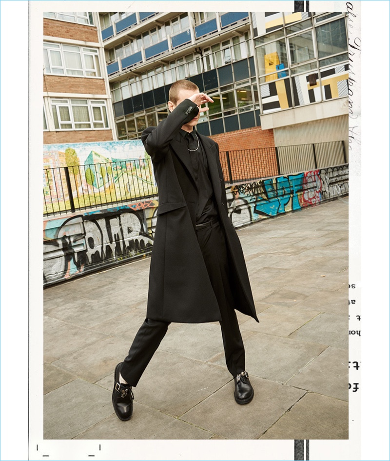 Dressed in black, Yuri Pleskun wears a Balenciaga coat and Les Hommes shirt with Z Zegna trousers. The model also sports Alexander McQueen shoes and an Ann Demeulemeester necklace.