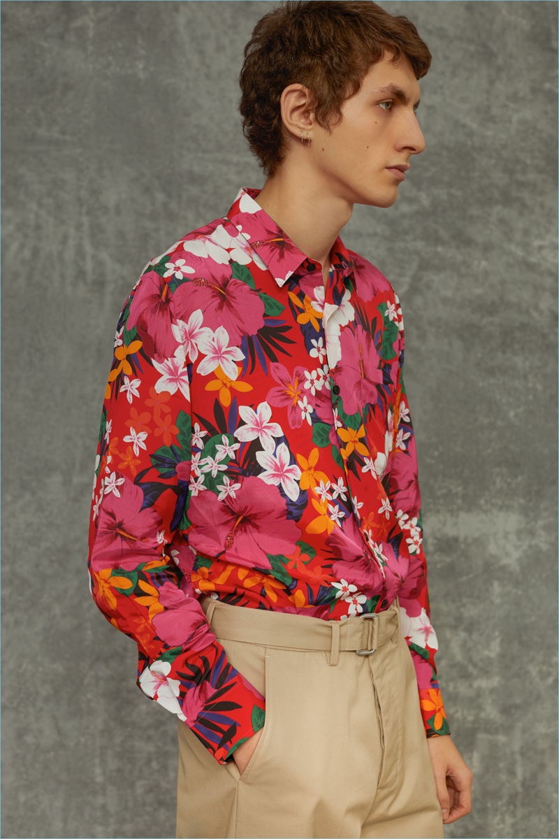 Delivering a side profile, Henry Kitcher wears a Hawaiian print shirt and pants by AMI.