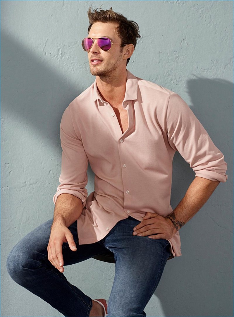 Rocking Ray-Ban sunglasses, Christian Hogue also wears a pink LE 31 shirt, and Calvin Klein jeans.