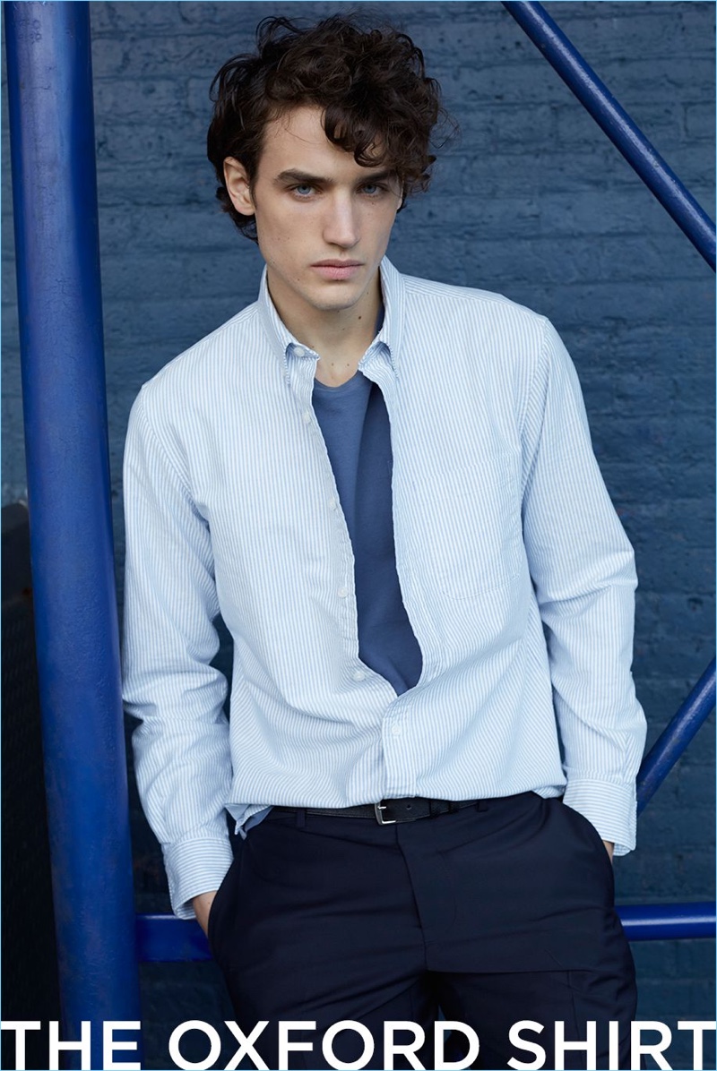 Make a smart impression with Club Monaco's stripe oxford shirt with a pocket t-shirt, suit trousers, and suede belt.