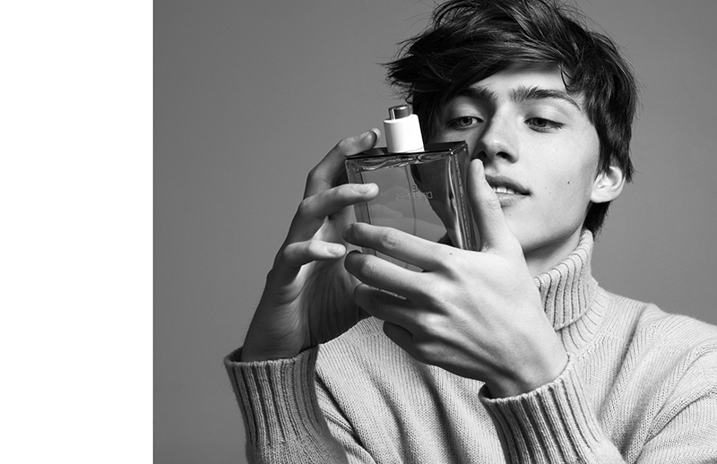 Starring in a black and white shoot, Sep examines a bottle of Terre d'Hermès.