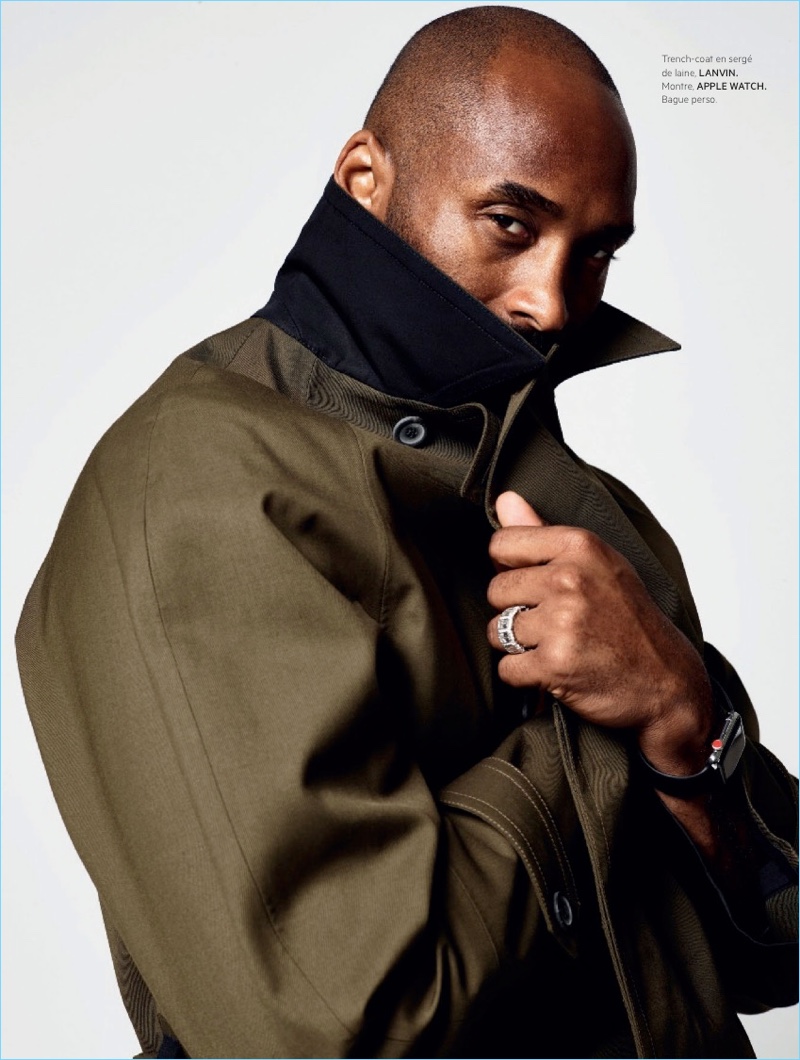 Delivering a side profile, Kobe Bryant wears a Lanvin trench coat and Apple watch.