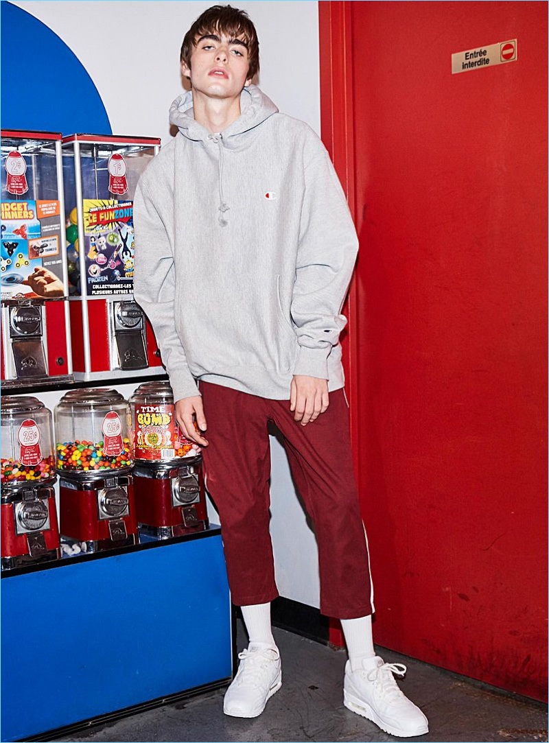 Sporting an oversized Champion hoodie, Lennon Gallagher also wears Fairplay track pants and Reebok Classic sneakers in white.