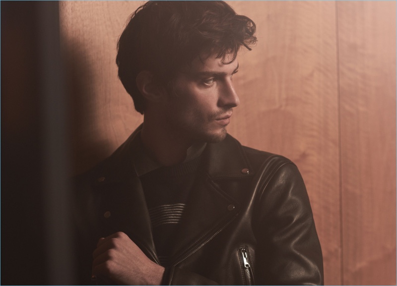 A cool vision, Matthew Bell wears a leather biker jacket and wide striped sweater by Reiss.