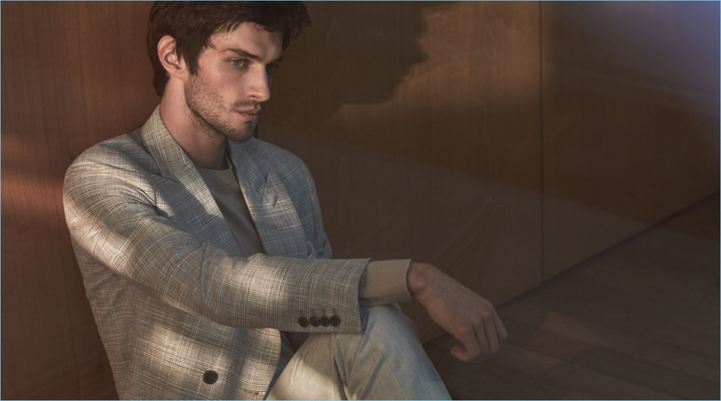 Suiting up, Matthew Bell dons a Reiss double-breasted blazer with a merino wool sweater and wool trousers.