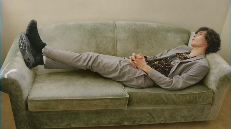 Lounging on a couch, Anton Jaeger dons a slim grey suit for Topman's spring 2018 campaign.